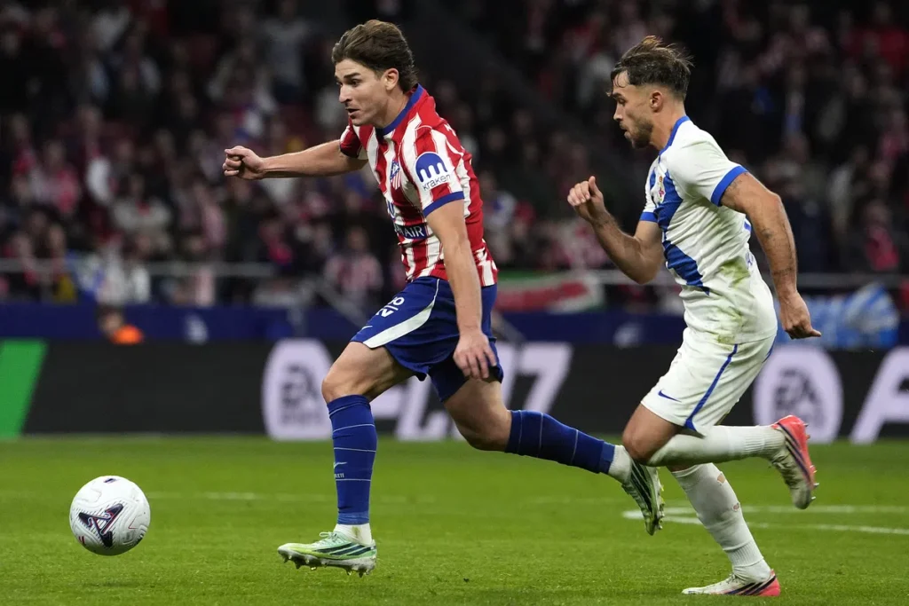 Atlético Madrid- en Barcelona-spelers sprinten achter de bal aan tijdens een voetbalwedstrijd.