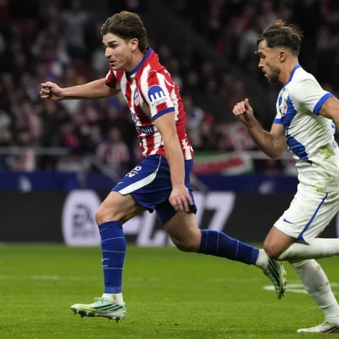 Atlético Madrid- en Barcelona-spelers sprinten achter de bal aan tijdens een voetbalwedstrijd.