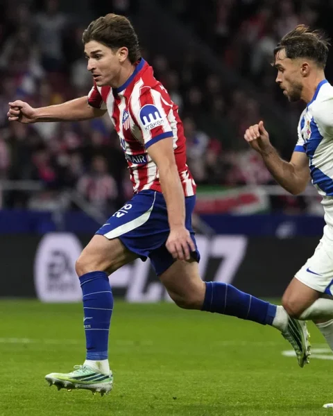 Atlético Madrid- en Barcelona-spelers sprinten achter de bal aan tijdens een voetbalwedstrijd.