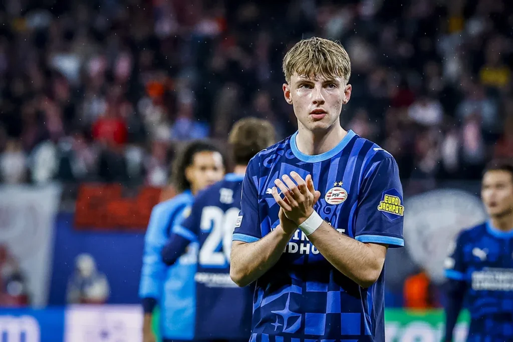 Een Jong PSV-speler in blauw tenue applaudisseert op het veld.
