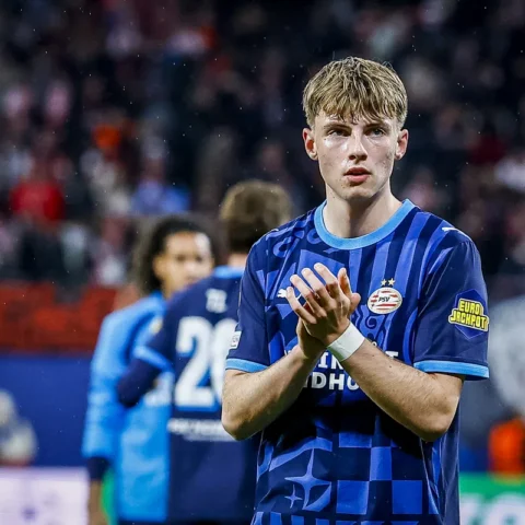 Een Jong PSV-speler in blauw tenue applaudisseert op het veld.