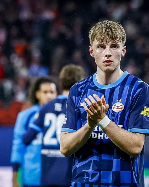 Een Jong PSV-speler in blauw tenue applaudisseert op het veld.