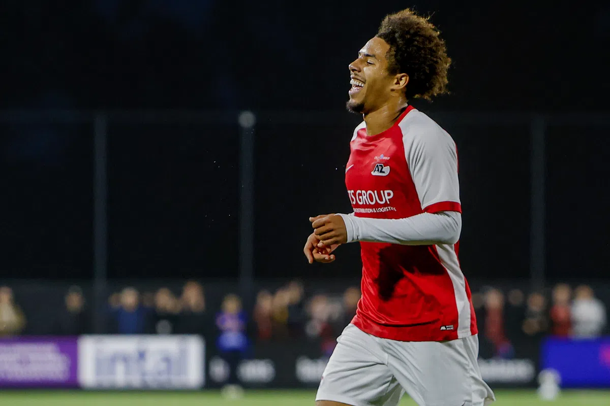 AZ-speler in rood-wit juicht tijdens een avondwedstrijd.