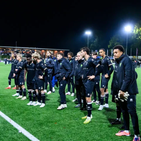 ADO Den Haag-spelers en staf staan na afloop van de wedstrijd op het veld bij kunstlicht.