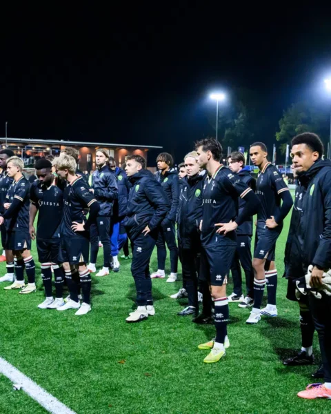 ADO Den Haag-spelers en staf staan na afloop van de wedstrijd op het veld bij kunstlicht.