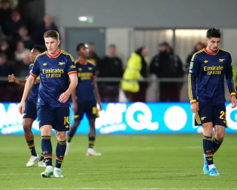 Arsenal-spelers lopen teleurgesteld op het veld tijdens een wedstrijd.