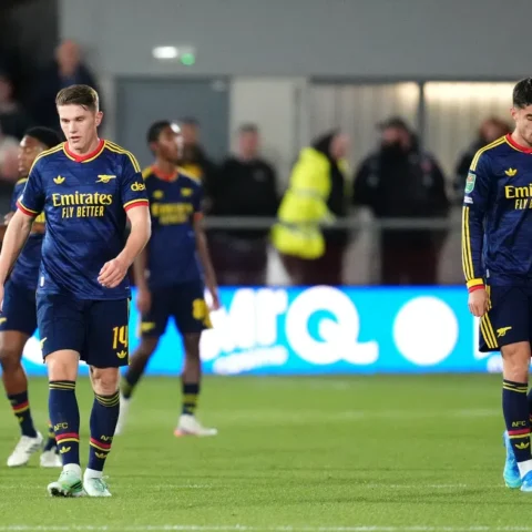 Arsenal-spelers lopen teleurgesteld op het veld tijdens een wedstrijd.
