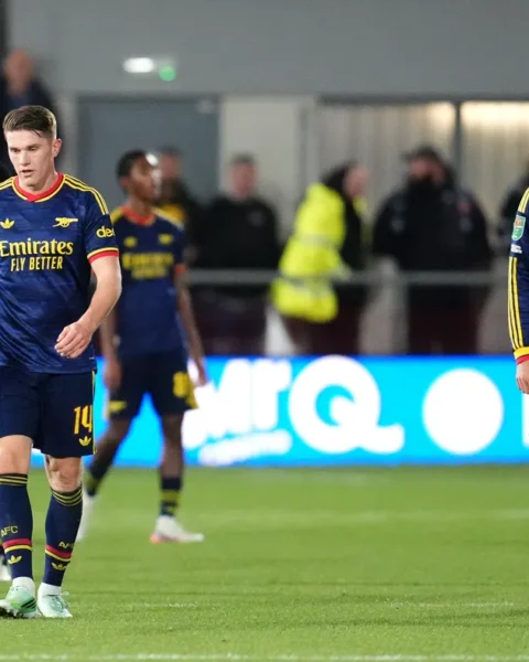 Arsenal-spelers lopen teleurgesteld op het veld tijdens een wedstrijd.