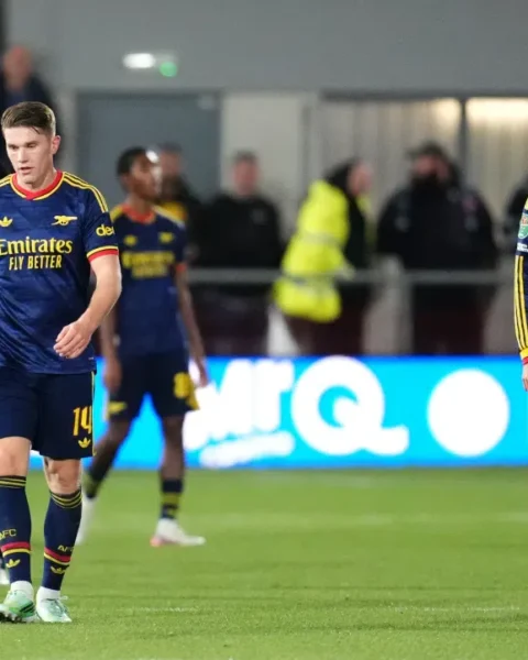 Arsenal-spelers lopen teleurgesteld op het veld tijdens een wedstrijd.