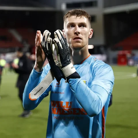 Mark Spenkelink in een lichtblauw keepersshirt klapt op het veld na de wedstrijd.