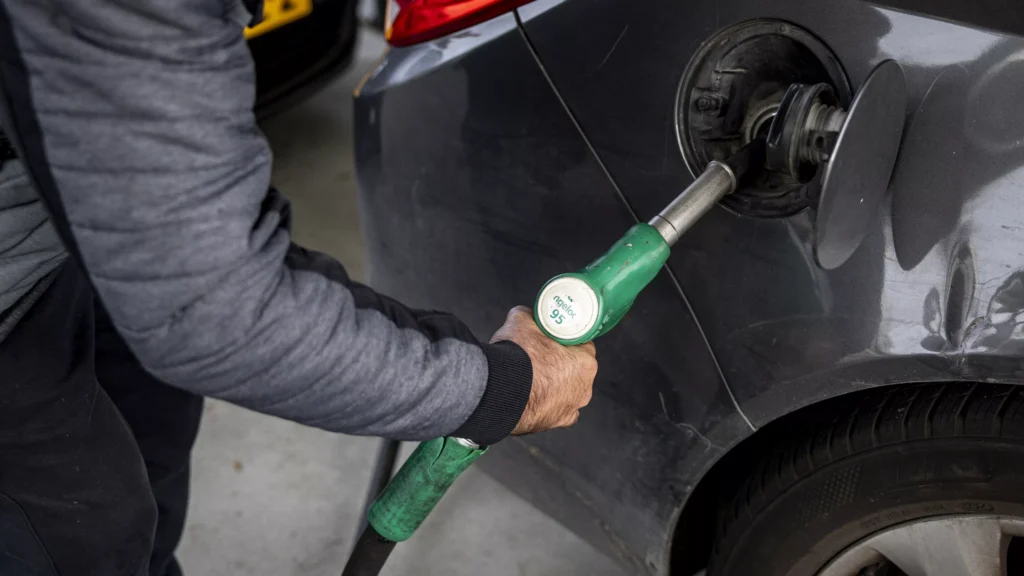 Iemand tankt brandstof in een auto bij een tankstation.