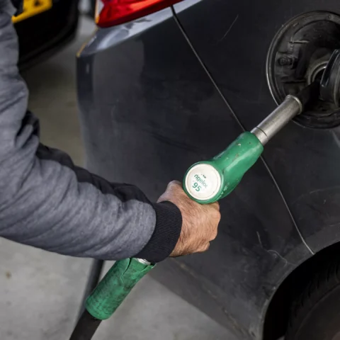 Iemand tankt brandstof in een auto bij een tankstation.
