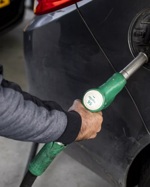 Iemand tankt brandstof in een auto bij een tankstation.