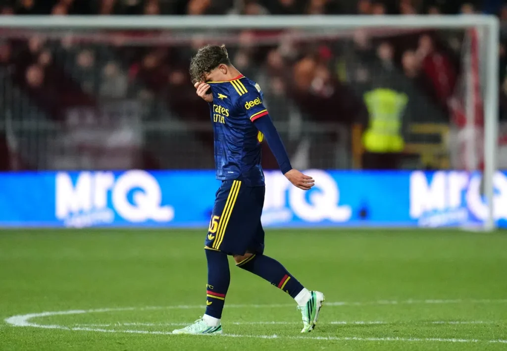 Arsenal-speler loopt teleurgesteld over het veld na een rode kaart.