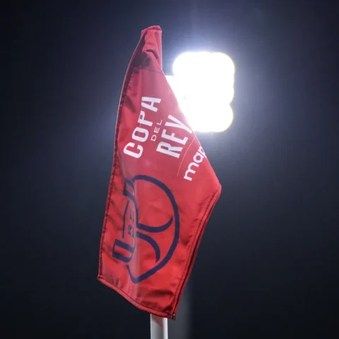 Rode cornervlag met Copa del Rey-opdruk in een stadion bij felle stadionlampen.
