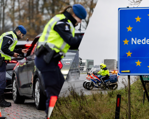 Nederlandse politie controleert voertuigen bij een grenscontrole, naast een bord met ‘Nederland’.