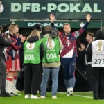 Harry Kane zwaait met beide handen terwijl hij met Bayern München-spelers en staf door een DFB-Pokal erehaag loopt.