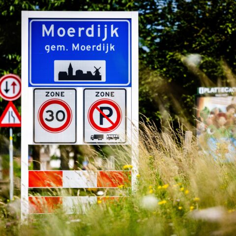 Bord bij de ingang van Moerdijk met plaatsnaam, snelheidszone en parkeerverbod.