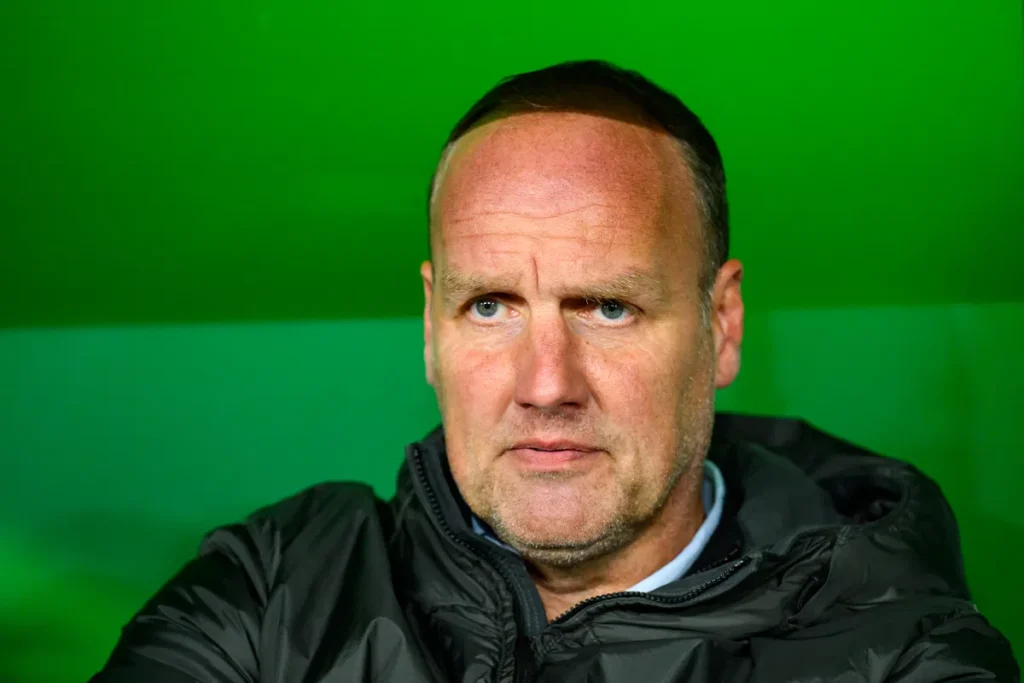 Portret van Dick Lukkien voor een groene achtergrond.