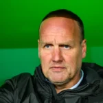 Portret van Dick Lukkien voor een groene achtergrond.