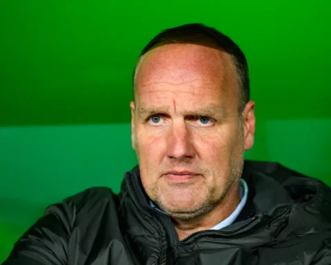 Portret van Dick Lukkien voor een groene achtergrond.