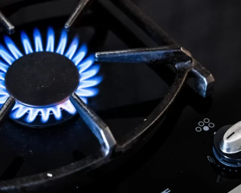 Blauwe gasvlam brandt op een gasfornuis.
