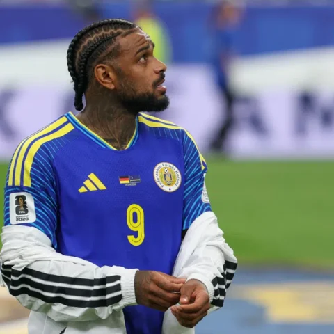 Curaçaose voetballer in blauw nationaal shirt kijkt omhoog op het veld.
