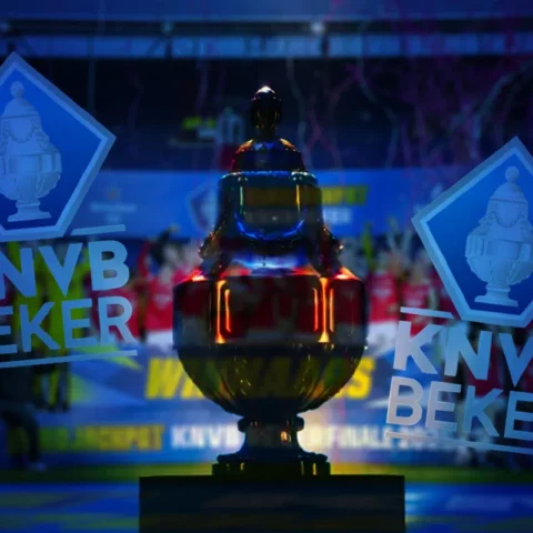 De KNVB-beker op een podium met het KNVB Beker-logo op de achtergrond.