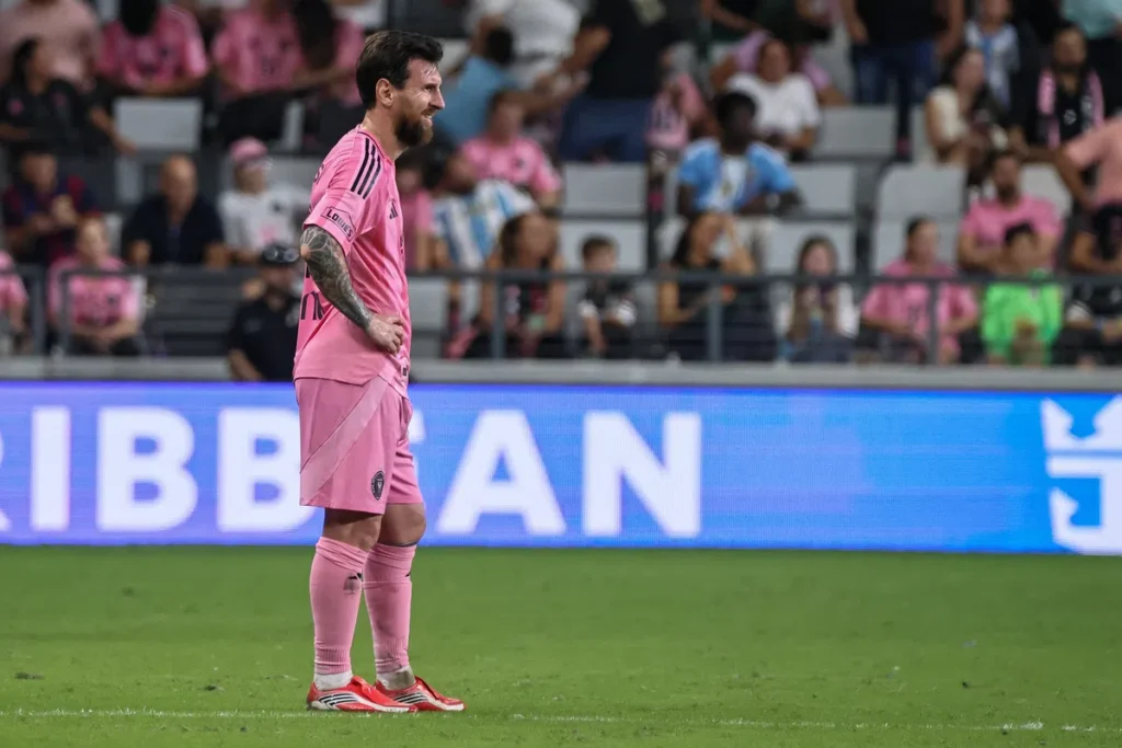 Lionel Messi staat op het veld in een roze Inter Miami-tenue tijdens een wedstrijd.