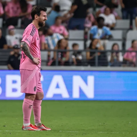 Lionel Messi staat op het veld in een roze Inter Miami-tenue tijdens een wedstrijd.