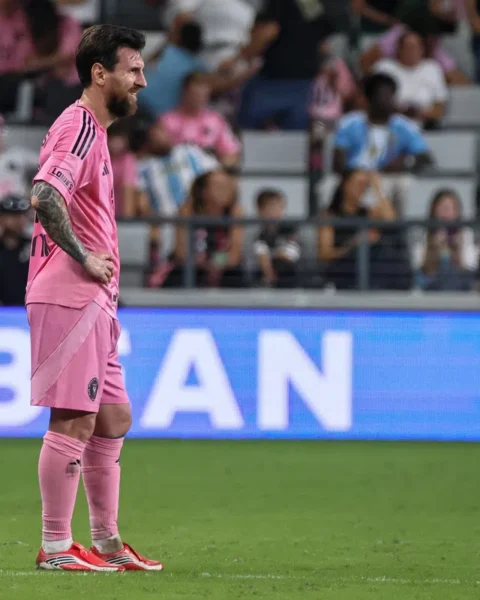 Lionel Messi staat op het veld in een roze Inter Miami-tenue tijdens een wedstrijd.