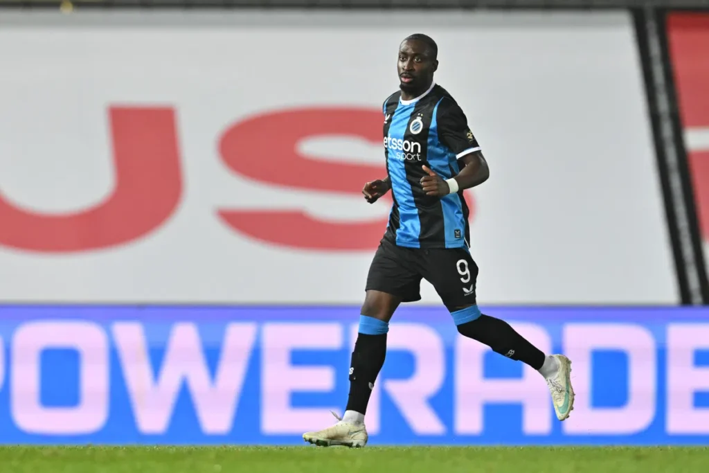 Speler van Club Brugge in zwart-blauw tenue rent over het veld tijdens een wedstrijd.