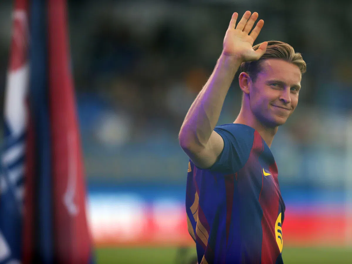 Frenkie de Jong zwaait naar het publiek in een FC Barcelona-shirt.