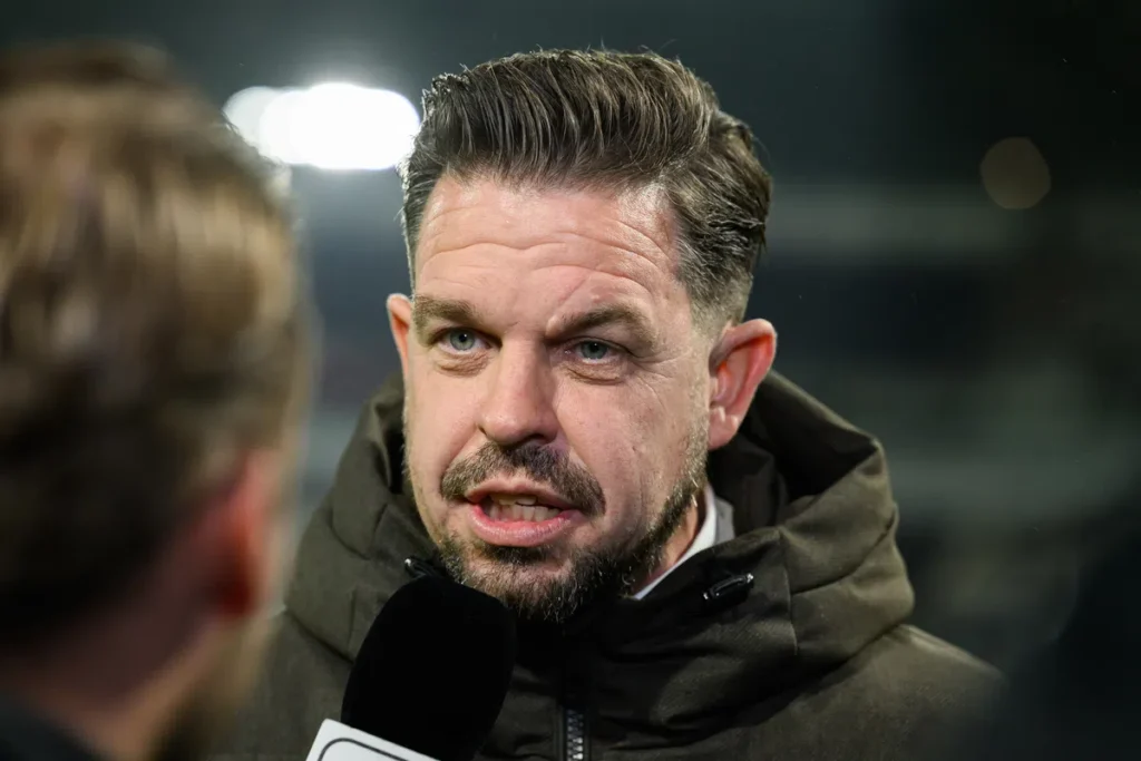 Sander Duits spreekt met een microfoon na een voetbalwedstrijd.