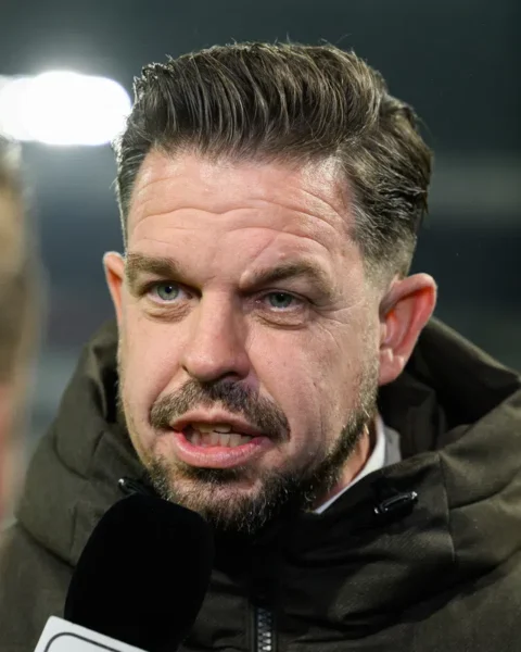 Sander Duits spreekt met een microfoon na een voetbalwedstrijd.