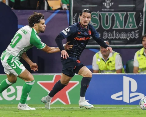 Twee voetballers vechten om de bal langs de zijlijn tijdens een wedstrijd.