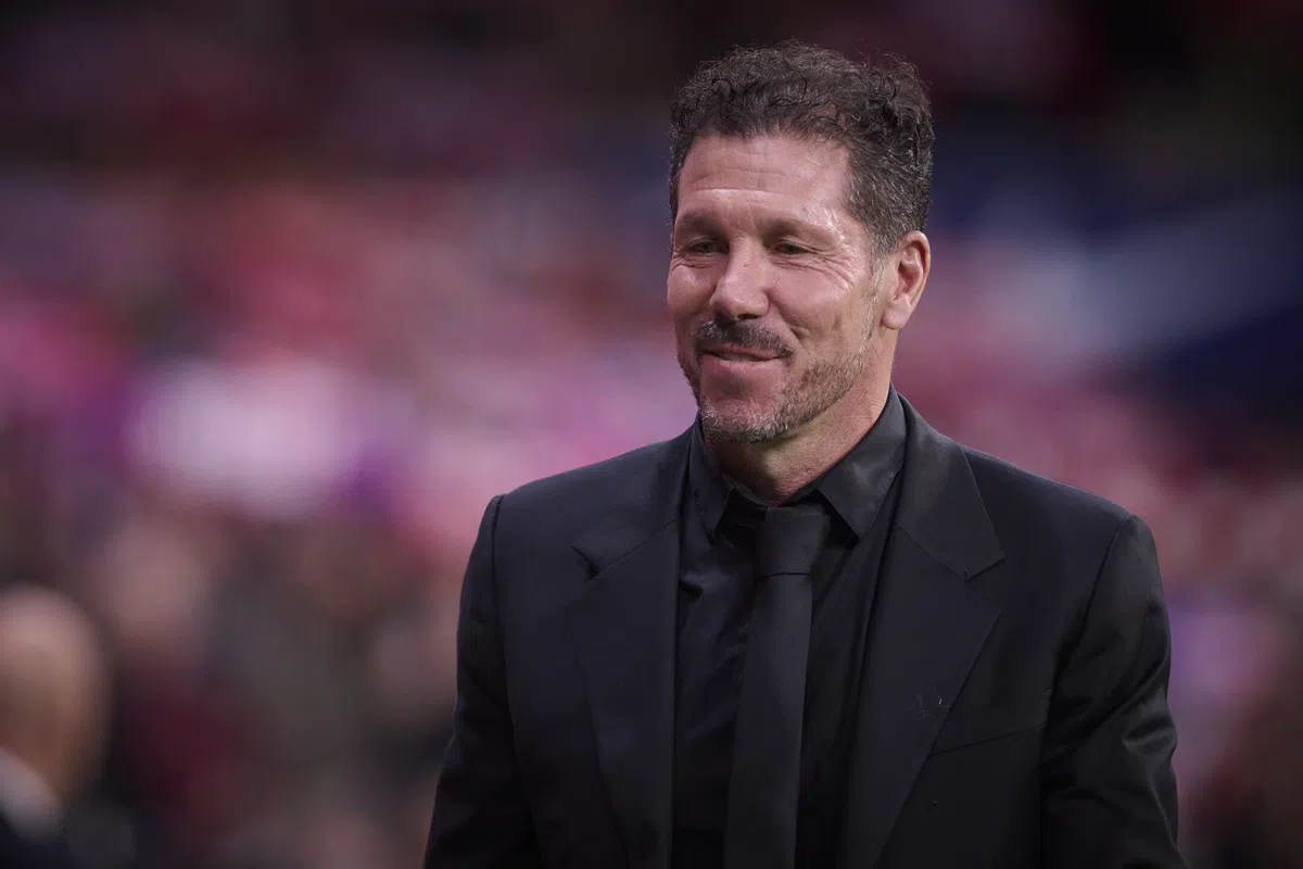 Diego Simeone staat in een zwart pak langs het veld in een stadion.