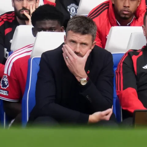 Michael Carrick zit gespannen op de bank van Manchester United tijdens een wedstrijd.