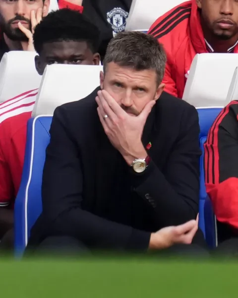 Michael Carrick zit gespannen op de bank van Manchester United tijdens een wedstrijd.