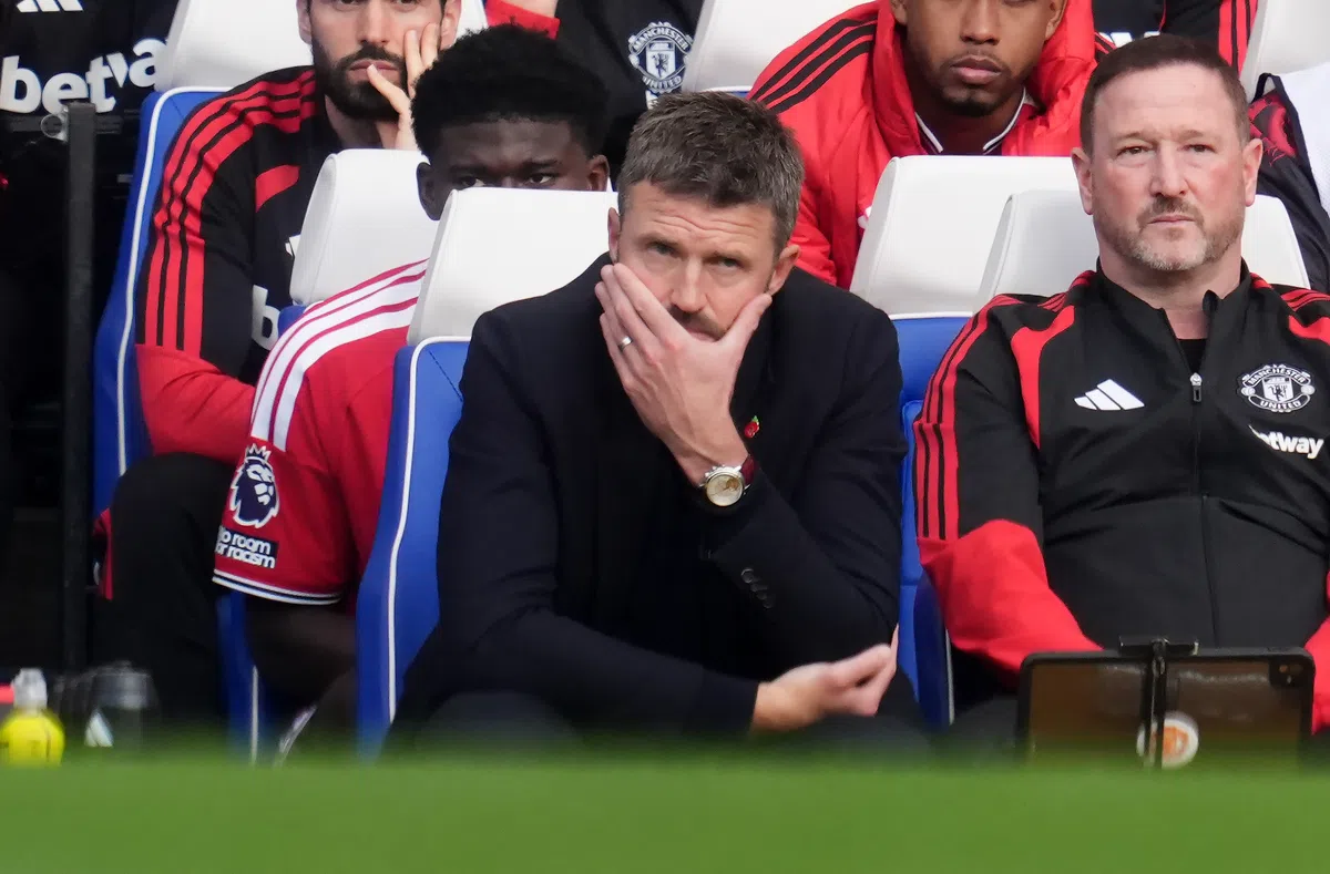 Michael Carrick zit gespannen op de bank van Manchester United tijdens een wedstrijd.