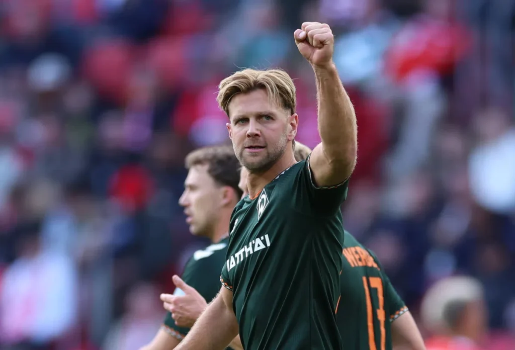 Niclas Füllkrug steekt zijn vuist omhoog in het Werder Bremen-shirt.