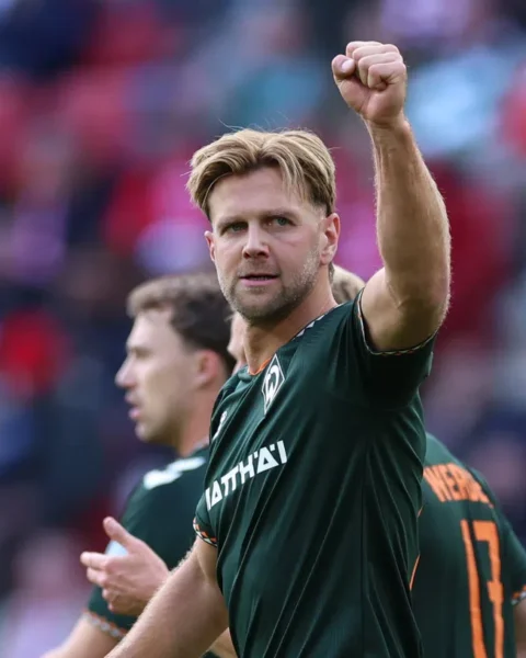 Niclas Füllkrug steekt zijn vuist omhoog in het Werder Bremen-shirt.