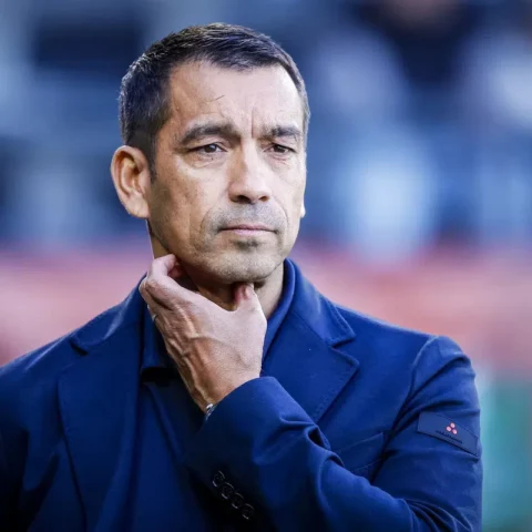 Giovanni van Bronckhorst staat langs de zijlijn met een nadenkende blik.