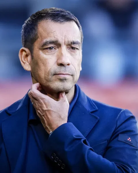 Giovanni van Bronckhorst staat langs de zijlijn met een nadenkende blik.