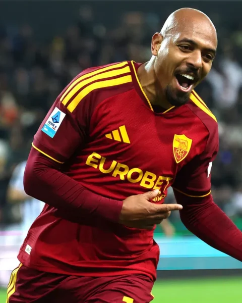 AS Roma-speler juicht op het veld in een rood tenue.