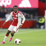 Ajax-speler in actie tijdens een voetbalwedstrijd.