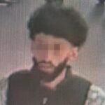 Wazige beveiligingsfoto van een man met donker haar en baard.