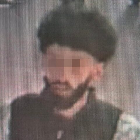 Wazige beveiligingsfoto van een man met donker haar en baard.