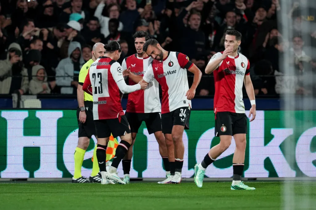 Feyenoord-spelers vieren een moment op het veld tijdens een wedstrijd.