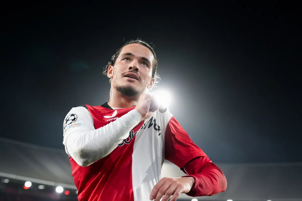 Feyenoord-speler in rood-wit shirt onder stadionlichten tijdens de wedstrijd.